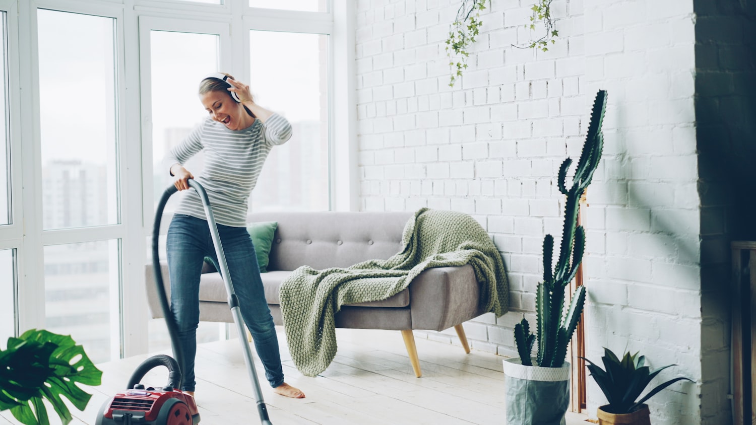 Cleaner vacuuming a bright, modern living room